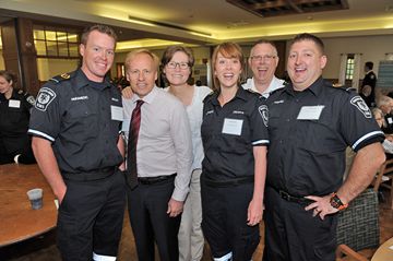 With his wife Colleen standing behind him, survivor Scott Ernst (second from left) shares a moment with EMS personnel Brad McEachnie, Debra Hunter, Terry Irwin and Lee Nordstrom.