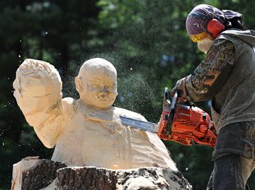 Aya Blaine meticulously removes material to reveal her carving of a child cancer survivor.