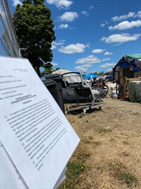 A document outlining the region’s court action to evict residents was attached to a fence in July at the encampment at Victoria and Weber streets in Kitchener.