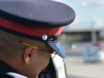 A police officer checks the speed of passing motorists.