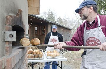 Volunteers Anton DeGiusti, left, and Dale Howey pull fresh loaves of bread from the oven, after arriving early to prepare dozens of loaves for sale to the public, Wednesdays from 3 to 5 p.m. Money raised helps support programs at Montgomery's Inn. (March 27, 2013)