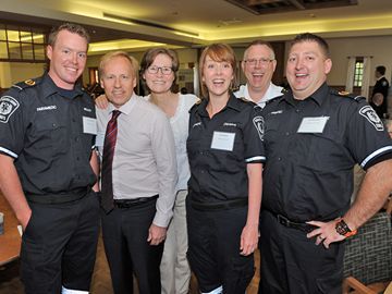 With his wife Colleen standing behind him, survivor Scott Ernst (second from left) shares a moment with EMS personnel Brad McEachnie, Debra Hunter, Terry Irwin and Lee Nordstrom.