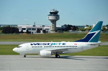 A WestJet aircraft is pictured on the tarmac in Ottawa on Thursday, July 2, 2015. A spate of bomb threats against Canadian airlines over the summer exposed what one airport executive believed were shortcomings in how the industry and federal government share information about threats, newly released documents show. THE CANADIAN PRESS/Sean Kilpatrick