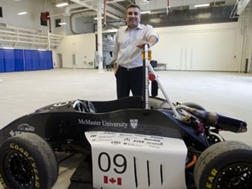 Ali Emadi, director of MacAUTO, shows off a hybrid car built by students at one of the McMaster Automotive Resource Centre garages.