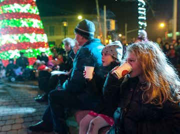 Six-year-old Eve Lounsbury and five-year-old Hannah Whiteson sip hot chocolate during the Cavalcade of LIghts event at the Alex Ling Fountain at Bloor and Jane streets Wednesday night. The annual event, which featured a tree-lighting ceremony, carolling and visit from Santa, was hosted by the Bloor West Village BIA . (Nov. 21, 2012)