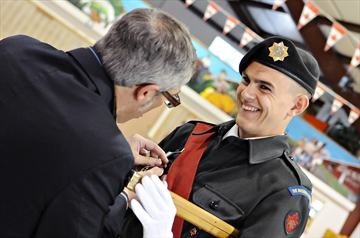 Warrant Officer Logan Pepper can barely contain his excitement as Parry Sound - Muskoka MP Tony Clement pins the Lord Strathcona Medal to his chest during the Muskoka Pioneers' annual parade on Saturday, June 2. (Photo by Louis Tam)