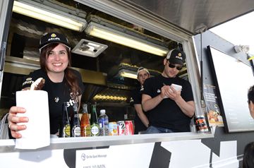 Lance Freeland, right, and Rachel Scott take and deliver orders of stuffed sausage aboard Stuft during the Food Truck Festival held Friday evening at Better Living Health and Community Services.  (May, 3, 2013)