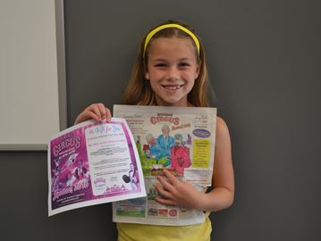 Eight year old Emily Grace Fahlman stands with her prize and her winning picture.