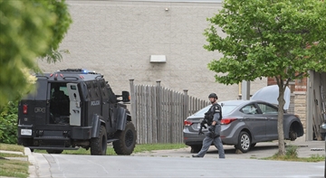 Members of the Hamilton Police Service's Emergency Response Unit leave a home on Candlewood Drive Thursday after executing a search warrant looking for at least four long guns stolen during a break in Tuesday night.