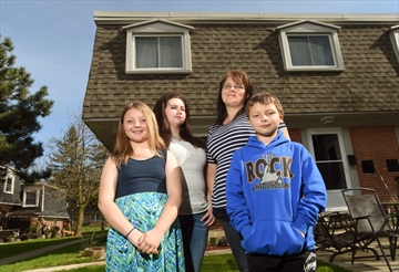 Jennifer Jensen stands with her children, from left, Abbagale Brandao, 10, Kayla Latulippe, 18, and Jackson Brandao, 9, in the front yard of their rental home on Borden Parkway in Kitchener. Jensen has seen rent in the region become less and less affordable for families