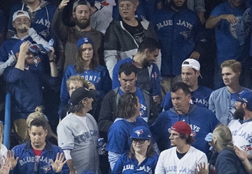 Pagan, center, stares straight ahead after the beer can is tossed onto the field