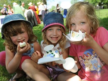Sisters Amy, Julia and Charlotte enjoy birthday cake in the town square.