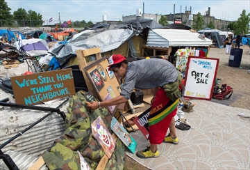  Jason Paul arranges his artwork that he sells in the homeless encampment at Weber and Victoria Streets in Kitchener.